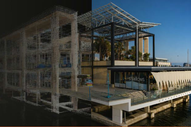 Glass-and-steel commercial building under construction on the waterfront